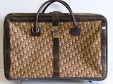 un sac marron et noir posé sur une surface blanche