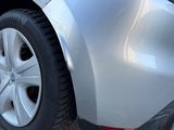 a silver car parked in a parking lot next to a parking meter