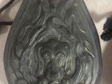 un vase noir avec un visage dessus à côté d'un vase noir