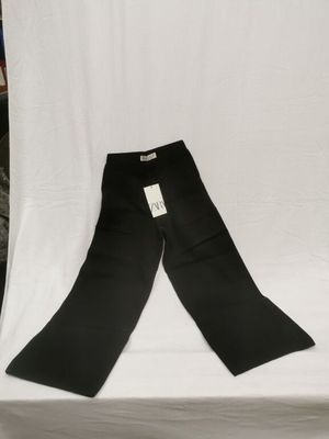 un pantalon noir posé sur une table blanche
