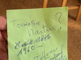 a person holding a piece of paper with writing on it