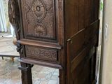 a wooden cabinet with carvings on the top of it