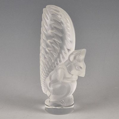 a white figurine of a cat with wings on a stand