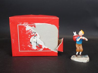 une petite figurine représentant un garçon tenant une batte de baseball