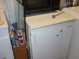 a microwave sitting on top of a refrigerator in a kitchen
