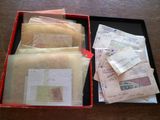 une boîte rouge remplie d'enveloppes et de timbres posée sur une table