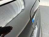a close up of a car door handle with a blue sticker on it