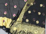 a close up of a black and gold shawl with flowers on it