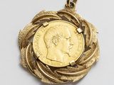 une image montrant un gros plan d'une médaille d'or posée sur une surface blanche