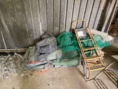 un tas de sacs en plastique et une échelle dans une pièce