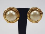a close up of a pair of earrings on a stand