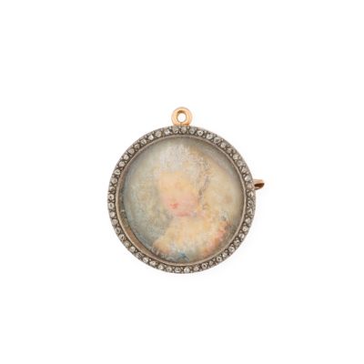 Un pendentif plaqué or représente le portrait ancien d'une femme vêtue d'une robe blanche.
