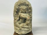 a close up of a stone head on a wooden base
