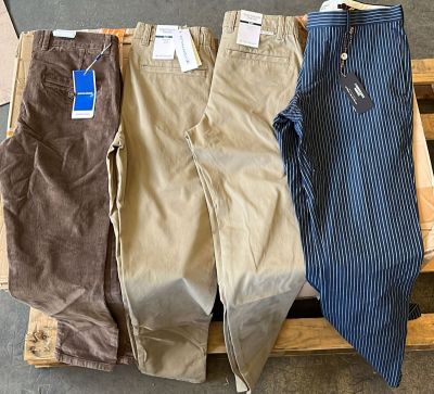 trois paires de pantalons pour homme posées sur une palette en bois