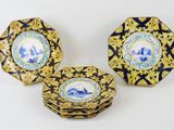 three blue and white plates with gold designs on them on a white surface