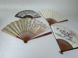 trois éventails chinois sont posés sur une table devant un fond blanc