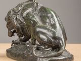 bronze statue of a lion on a rock on a table