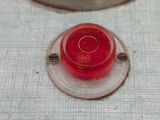 a close up of a red button on a white surface