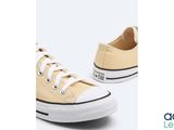 a pair of yellow sneakers with white laces on a white background