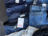 several pairs of jeans are laid out on a table with price tags