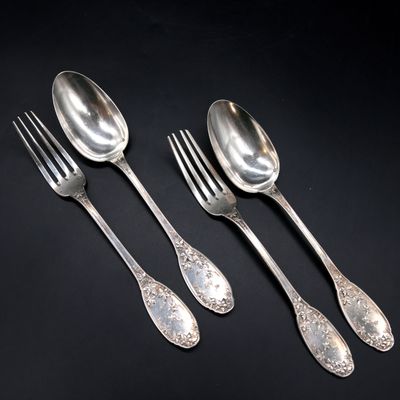 three silver spoons and a fork on a black surface