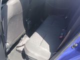 a blue car with the back seats down and the door open