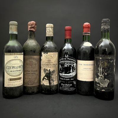 Plusieurs bouteilles de vin sont alignées sur un fond noir