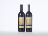 two bottles of wine sitting on top of a white table