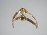 a close up of a gold bracelet with a stone on it