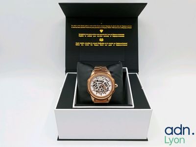 une boîte avec une montre à l'intérieur sur une surface blanche