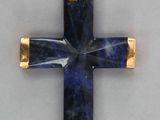un gros plan d'une croix avec une pierre bleue au centre