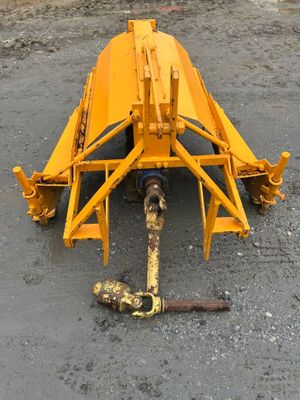 the front end of a yellow tractor is laying on the ground