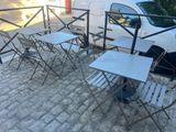 Des tables et des chaises sont disposées devant une camionnette blanche