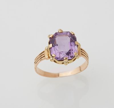 a gold ring with an amethorate stone in the center