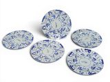 quatre assiettes bleues et blanches ornées de motifs sur fond blanc