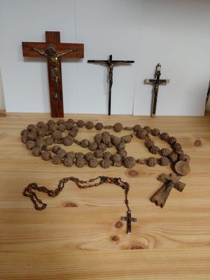 a rosary, a cross, and a rosary on a wooden table