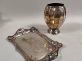 a silver tray and a silver vase on a table