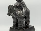 statue of a man riding a horse with a dog on its back