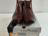 des chaussures en cuir marron posées sur une boîte, sur une surface blanche