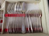 a lot of silverware in a box with red handles