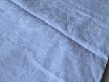 a blue towel on a bed with a white comforter