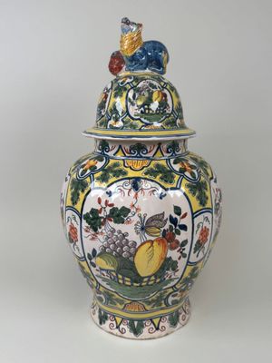a vase with a lid that has a bird on it