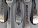 six forks and spoons are arranged in a row on a table