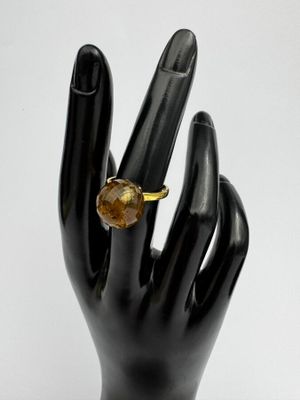 main de mannequin noire tenant une bague sertie d'une citrine