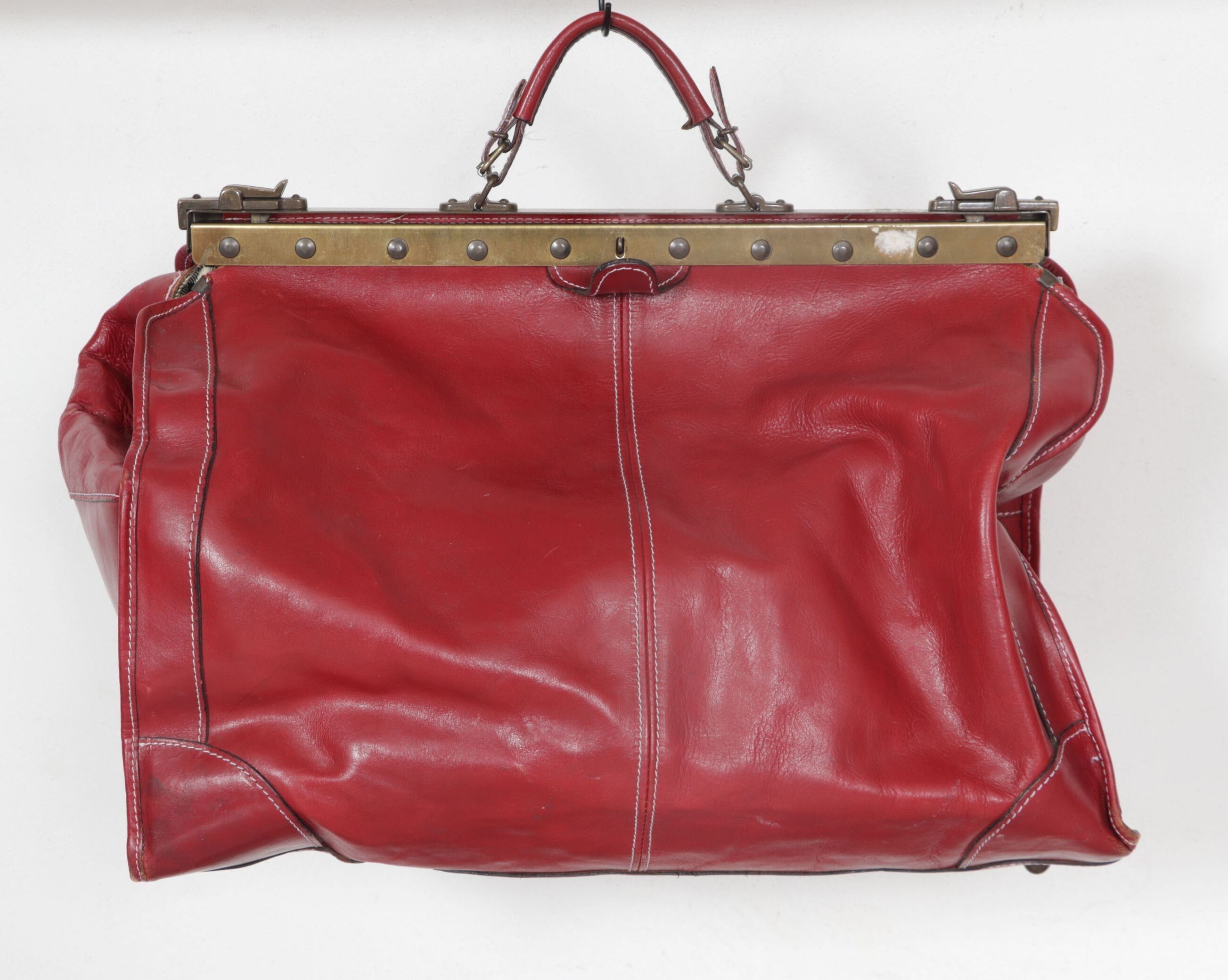 Sac de voyage en cuir rouge, à une anse. Ouverture à soufflet. Intérieur tartan. Made in Italy. H_42 cm L_52 cm P_24 cm
