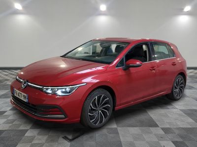 a red volkswagen golf is parked in a room with a checkered floor
