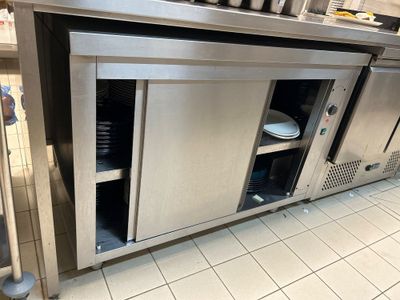 une grande cuisine en inox équipée d'un lave-vaisselle intégré au plan de travail