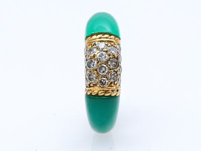 une image d'une bague avec une pierre verte entourée de diamants
