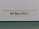 a close up of a hp envy 6110e label on a computer