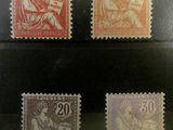 quatre timbres différents provenant de différents pays, exposés dans une vitrine